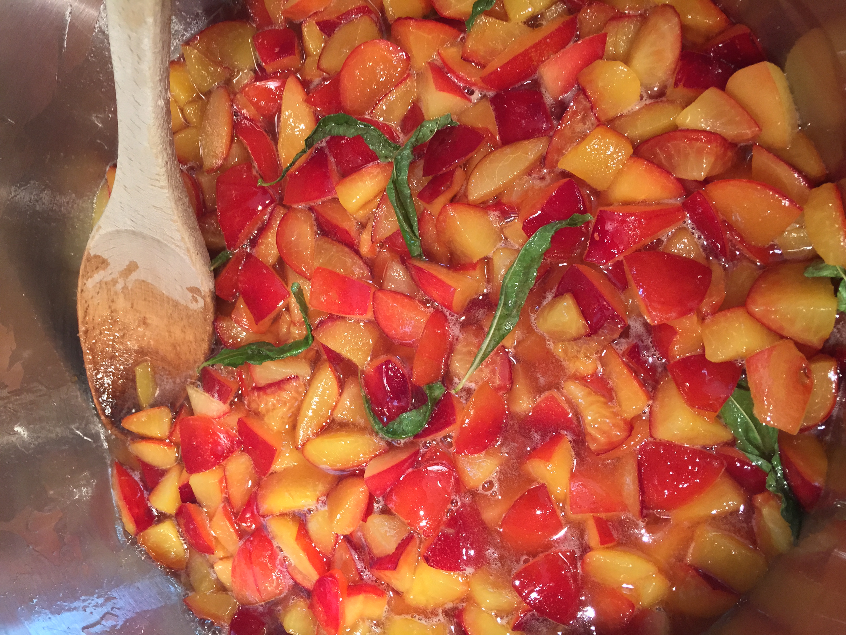 Plums, boiling away in honey with lemon verbena, before transforming into jam.