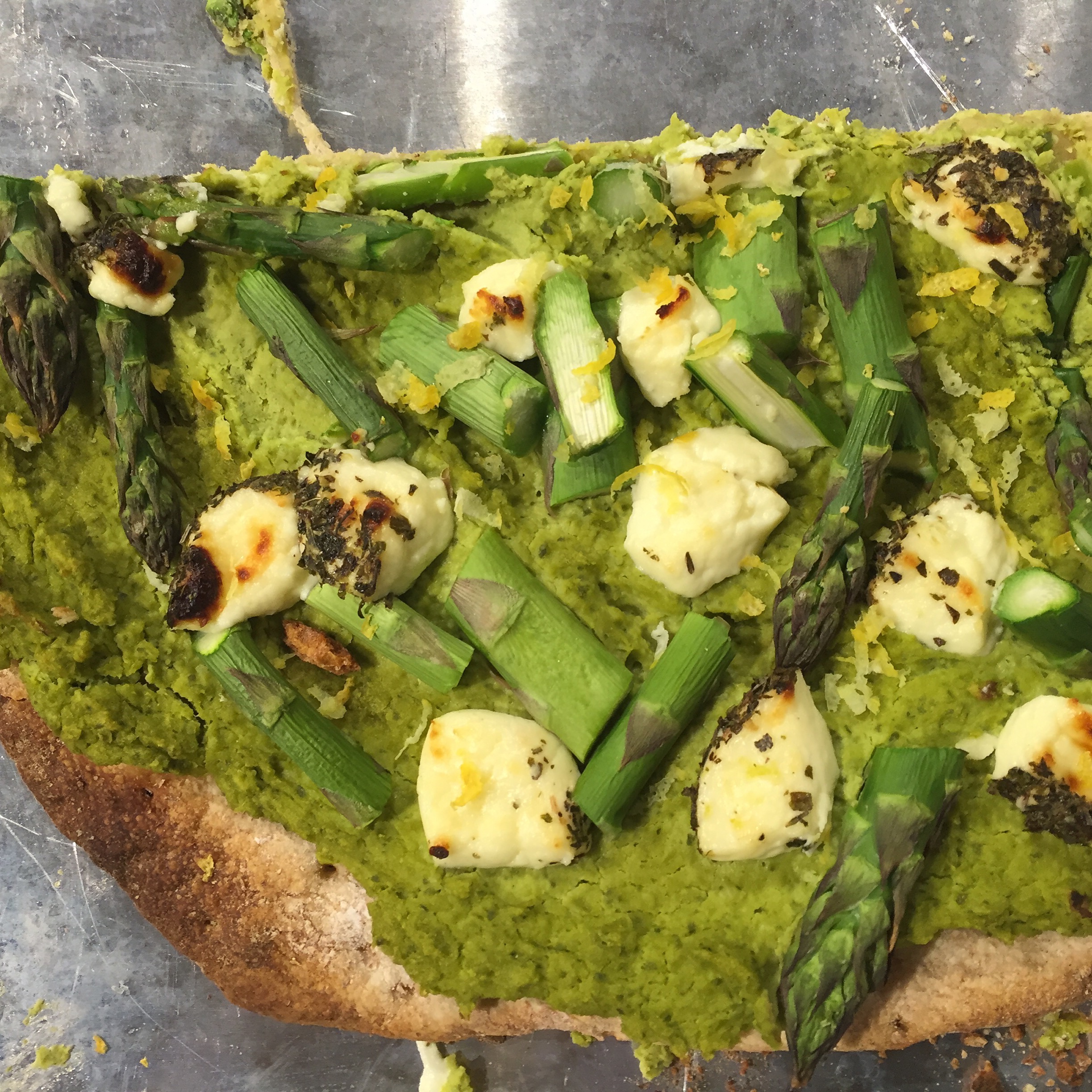 Pizza with pea-cilantro hummus, asparagus, herbed chevre and lemon zest