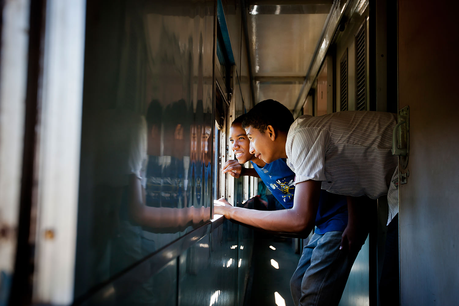 Tazara Express - Two guys looking the landscape outside the window. Zambia 