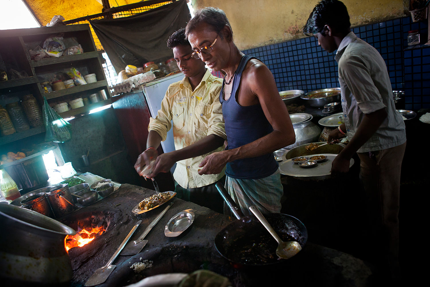 Three men working in a kitchen in a small restaurant in Bokaro- India