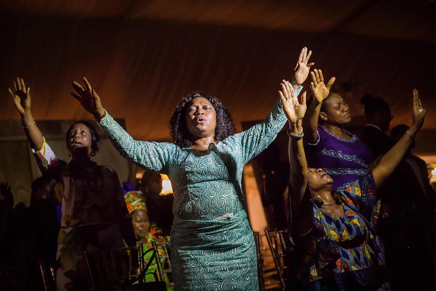 A group of women praying at a party before a wedding