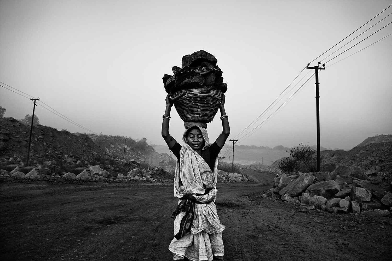 A woman is carrying a basket full of coal. Bokaro- India