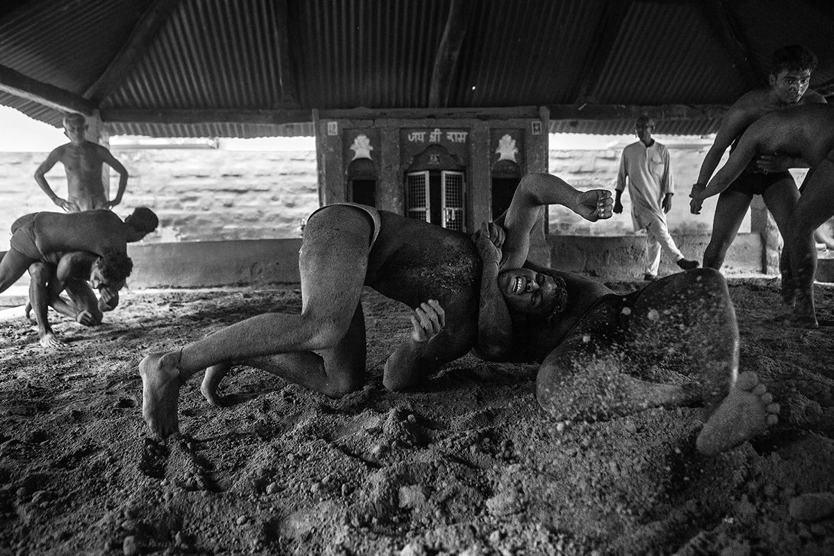 3 couples of wrestlers are fighting at the same time under the supervision of the  2 Guruji (masters)