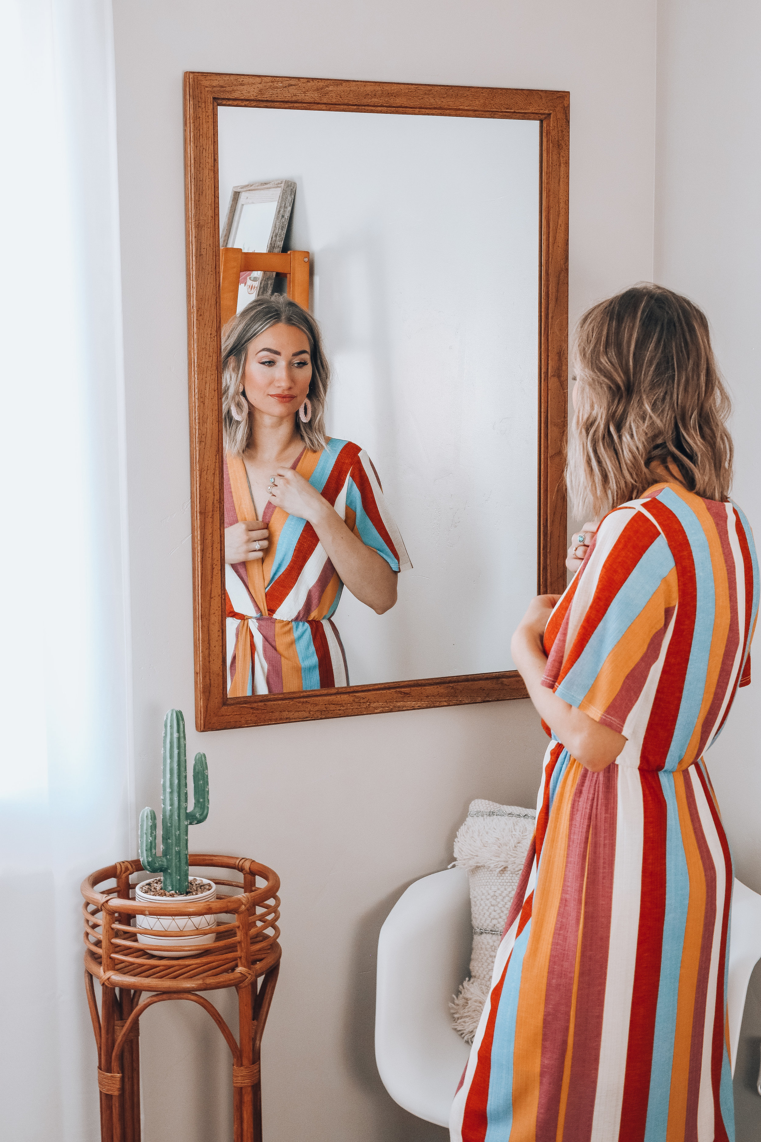 Karlee Andrews looks in a mirror, admiring her outfit put together with fearless fashion tape