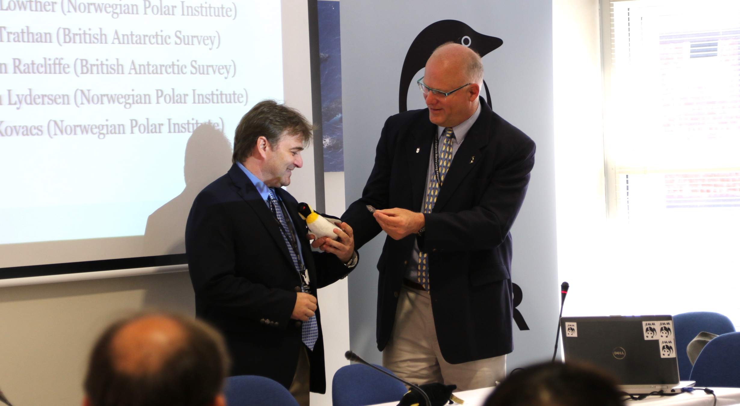 Werner handing over the AWR-penguin to Chris Reiss after his presentation on krill ageing methods. Photo: Monica Hägglund Langen