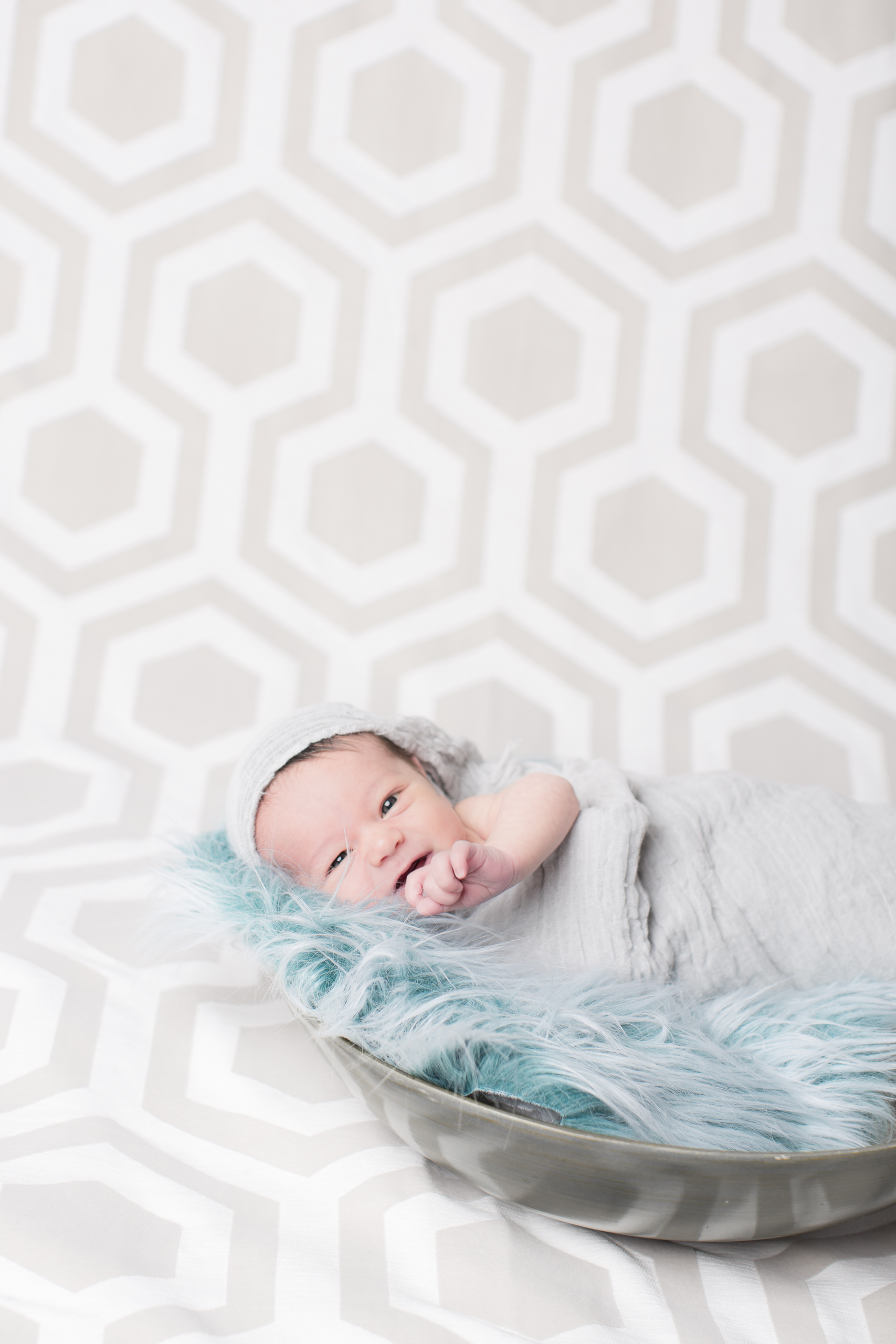 03 modern newborn baby boy blue swaddle in bowl modern hexagon backdrop studio photography session.jpg