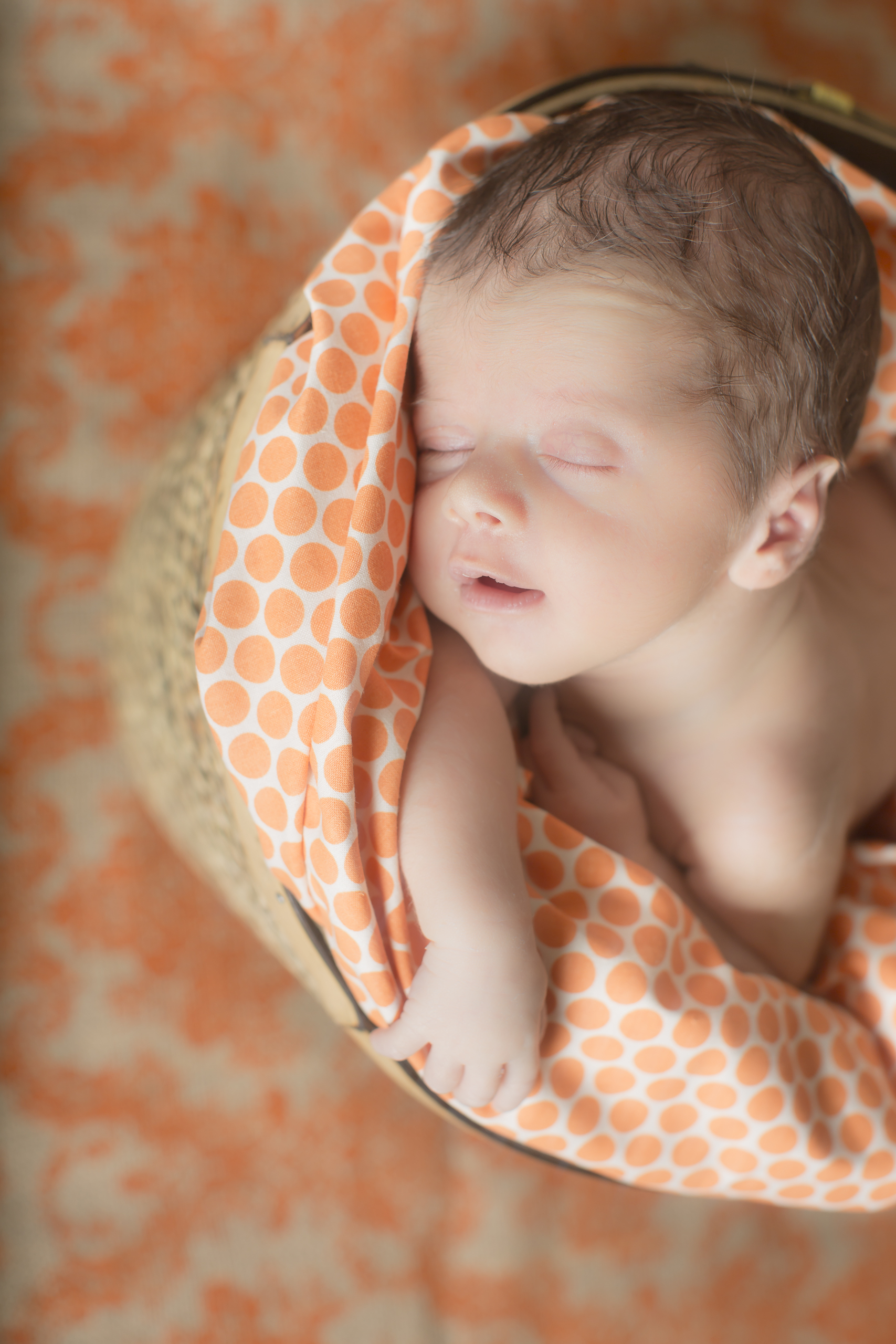 15 orange polka dot modern newborn boy photography in straw basket with burlap background studio session.jpg