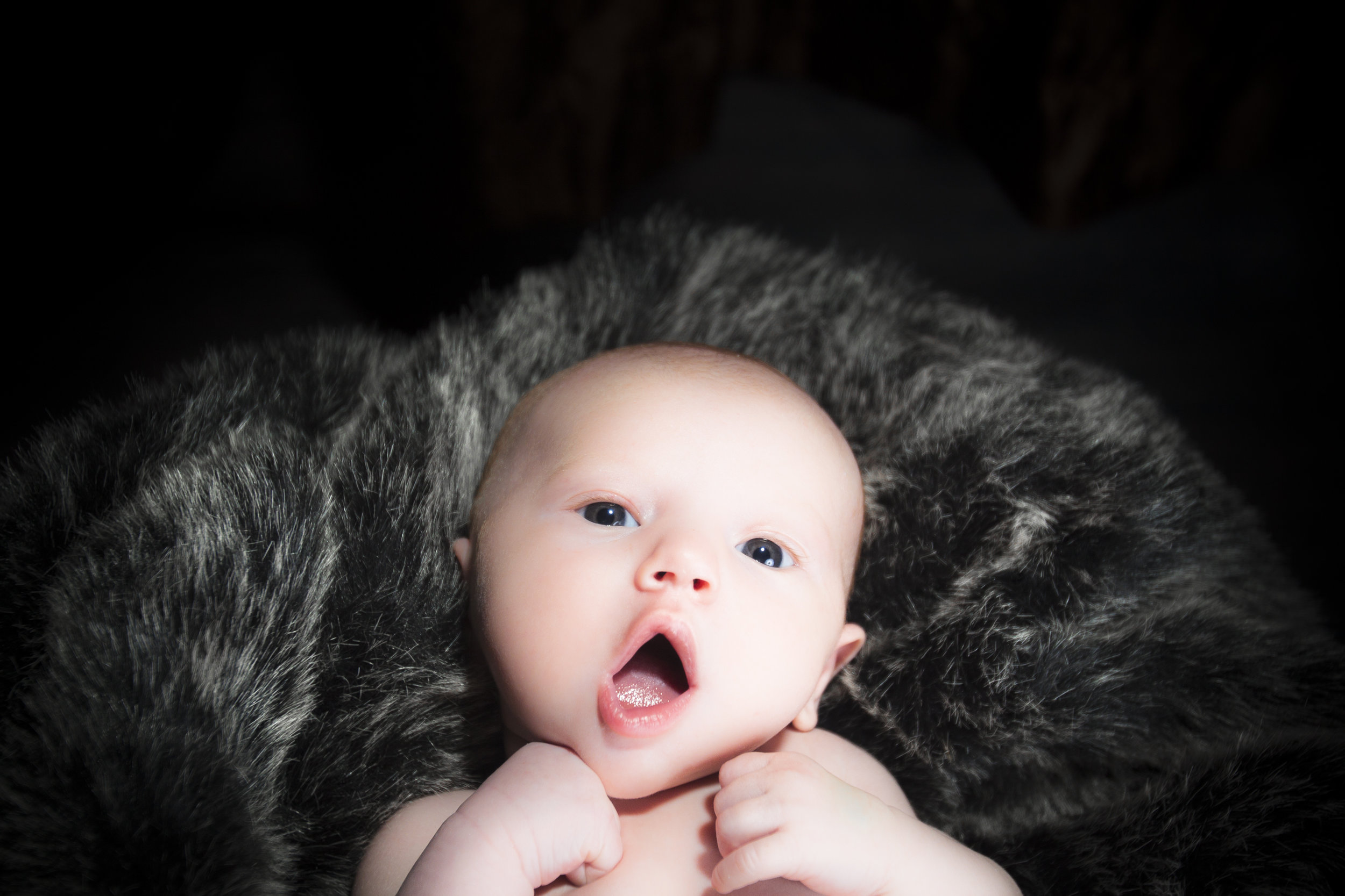 35 newborn baby boy big eyes on grey fur blanket studio session photography.jpg