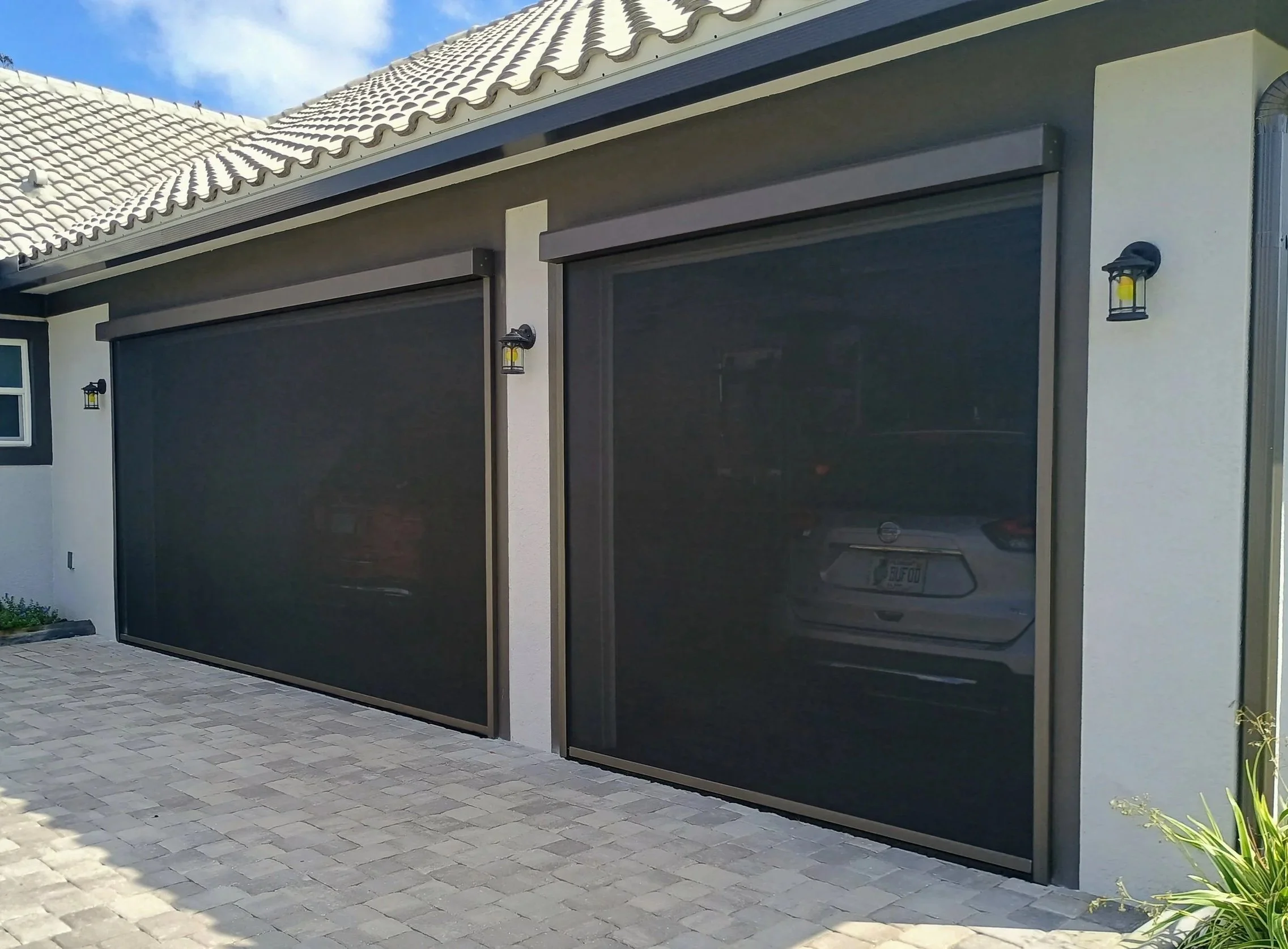 Exterior of a house with motorized garage screens. Single car and double car garage.