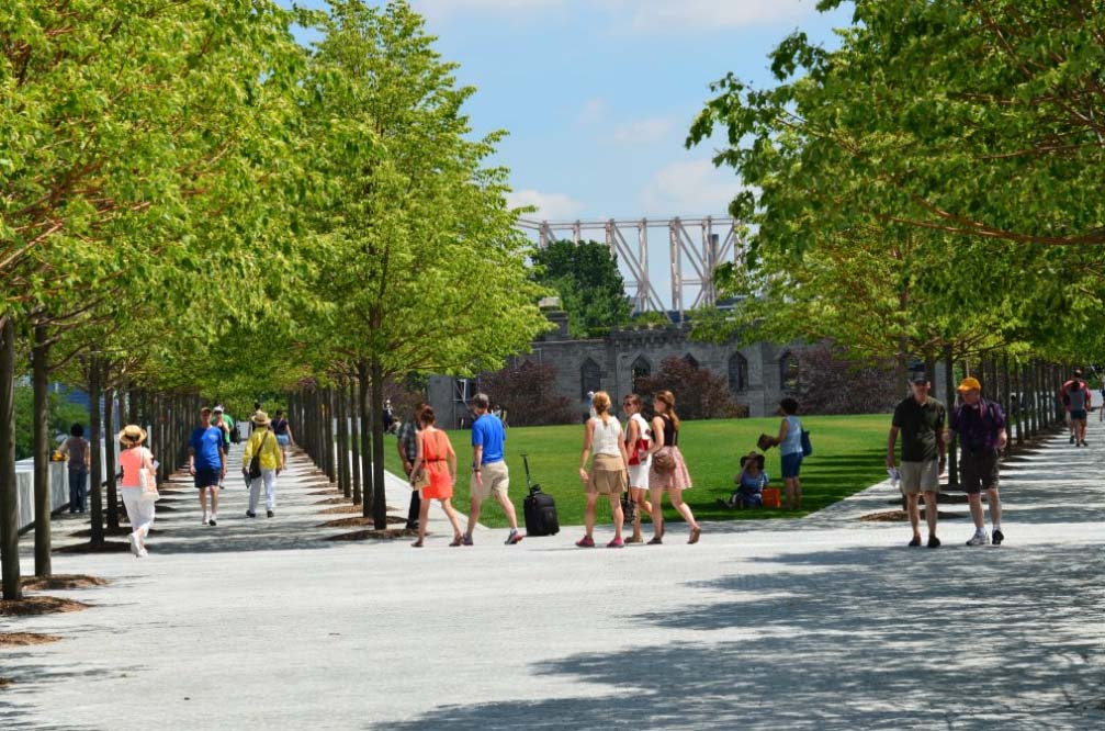 Park visitors on the lawn and strolling beneath the Littleleaf Linden trees.