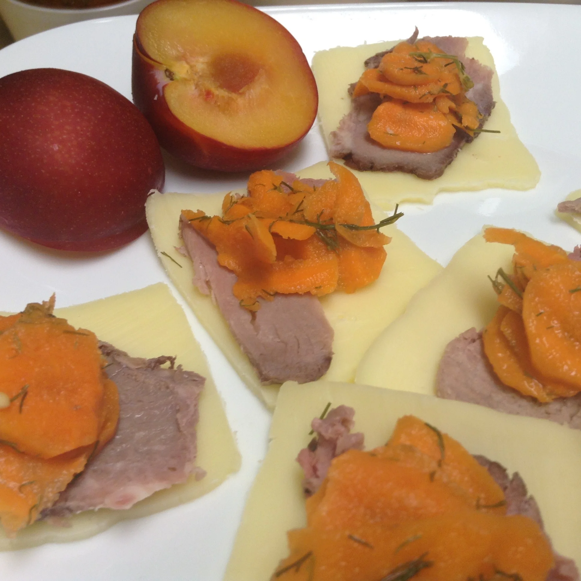 fermented dilly carrots on top of grass-fed beef slices and raw cheese