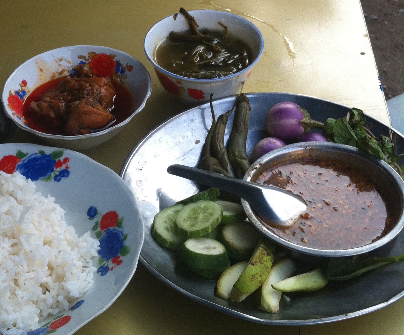 Spicy chicken. But note the sides: raw eggplants mint, some incredibly sour leaves, cucumber, boiled beans maybe, and something like very firm and tart green mango. 