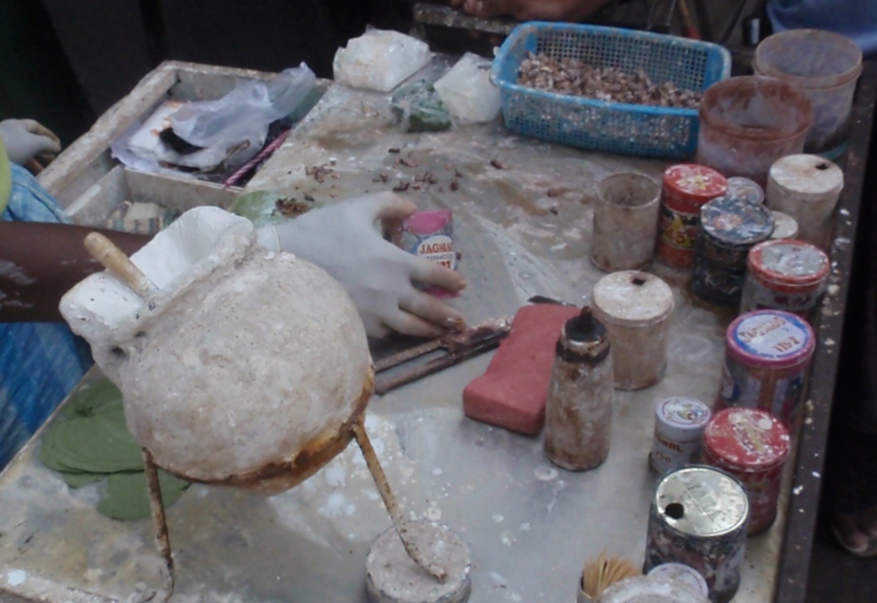 The white urn contains the lime they slake on each leaf prior to putting in the betel, tobacco, and all else