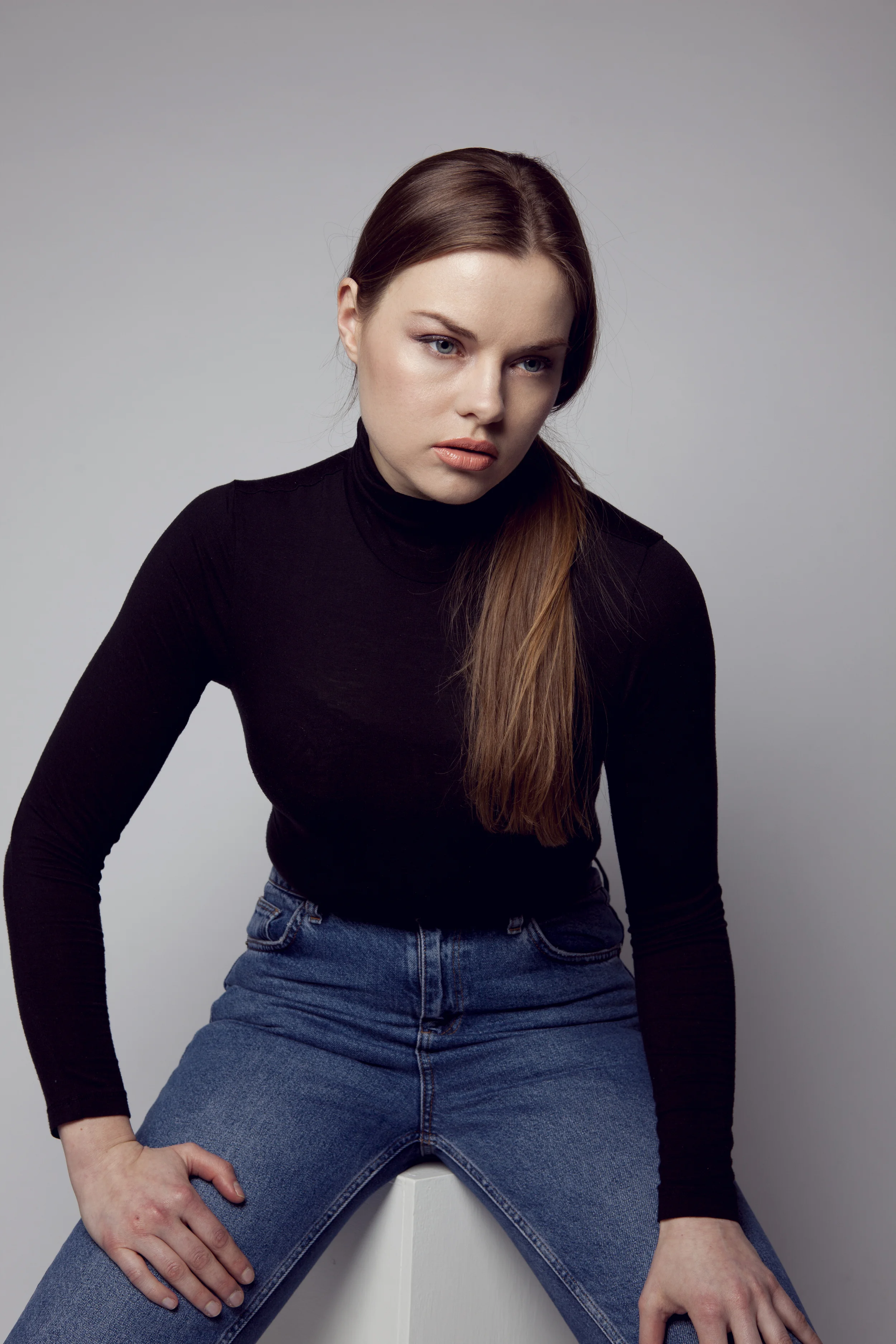 Woman in black trench coat with black turtleneck and jeans