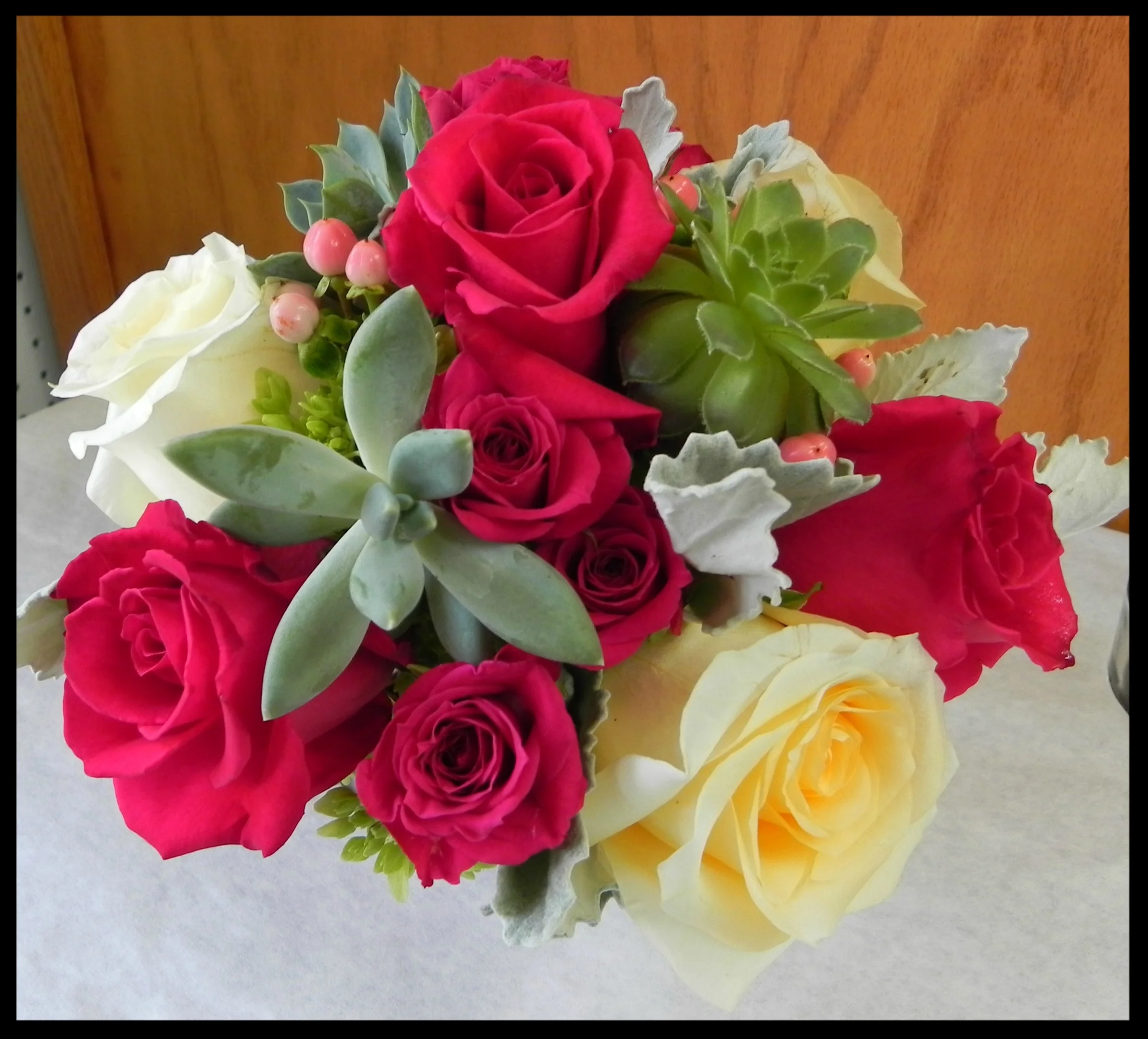 Hot pink and yellow roses with succulents.jpg