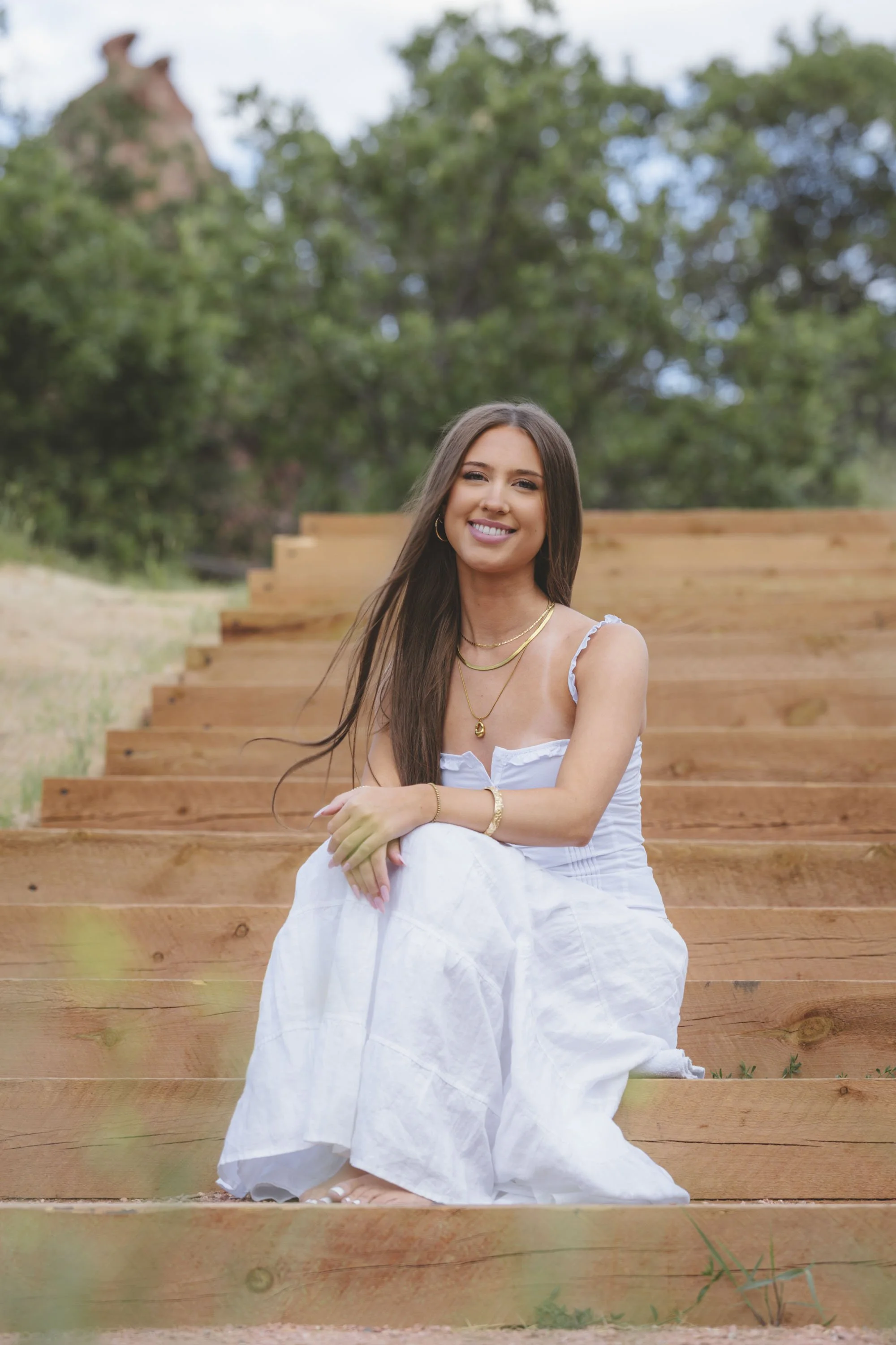 Beautiful Colorado senior portraits of a girl in white in nature.