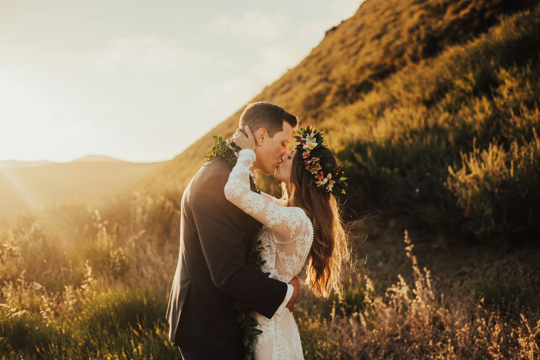 Bride with boho flower crown kisses groom at sunset photographed by Big Sur Wedding Photographers Tessa Tadlock 