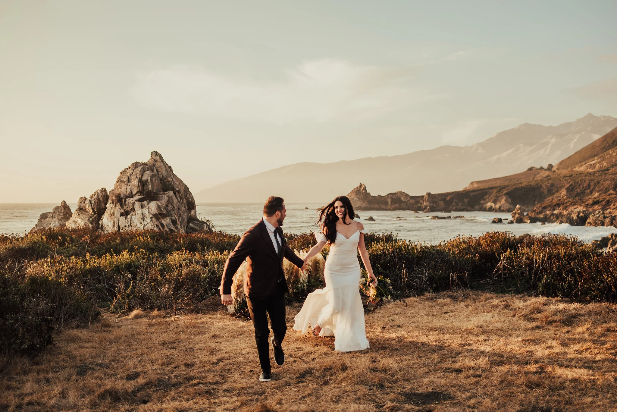 Bride &amp; Groom run along the coast photographed by Big Sur Wedding Photographers Tessa Tadlock 