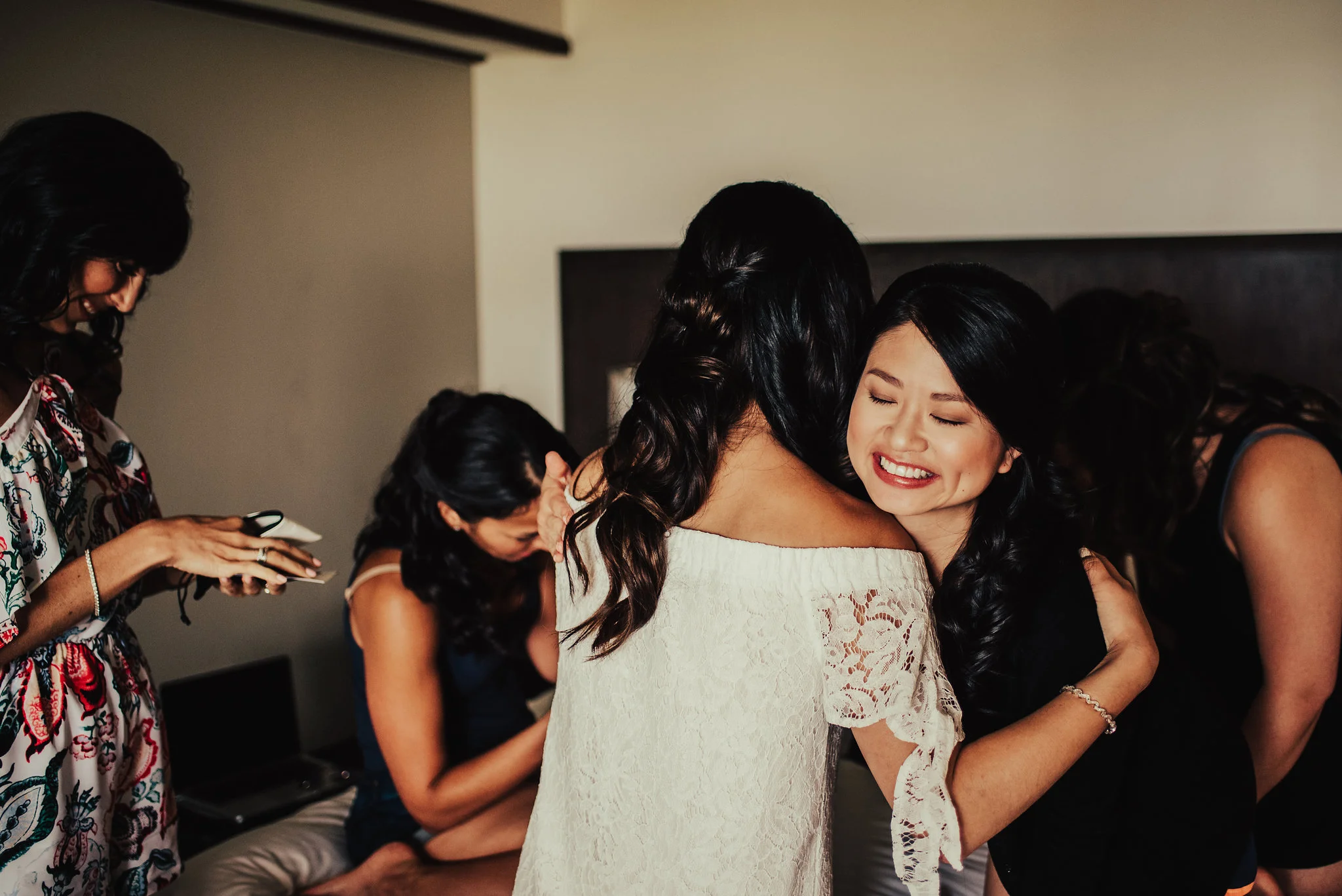 Bride hugging bridesmaids while getting ready Photographed by Santa Barbara Wedding Photographers Tessa Tadlock