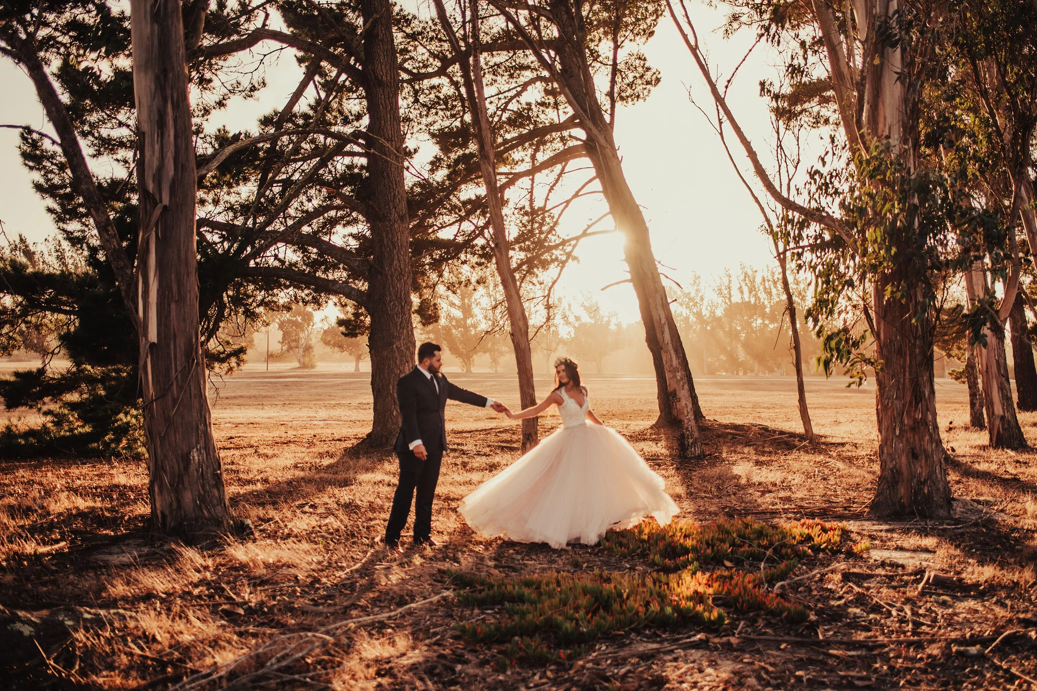 Groom &amp; Bride hold hands after fairytale wedding in the woods for sunset portraits photographed by Big Sur Wedding Photographers Tessa Tadlock 