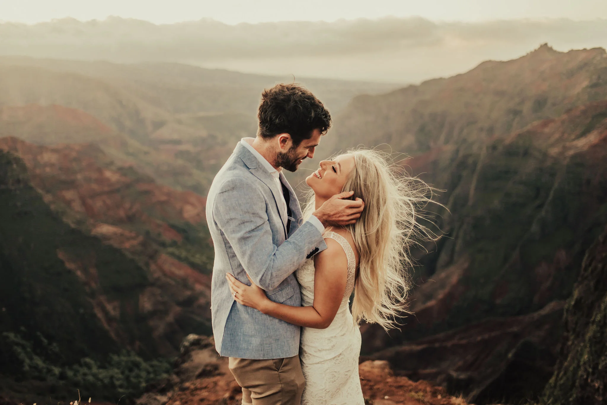 Romantic bride &amp; groom portrait on windy Hawaii cliffside photographed by Big Sur Wedding Photographers Tessa Tadlock 