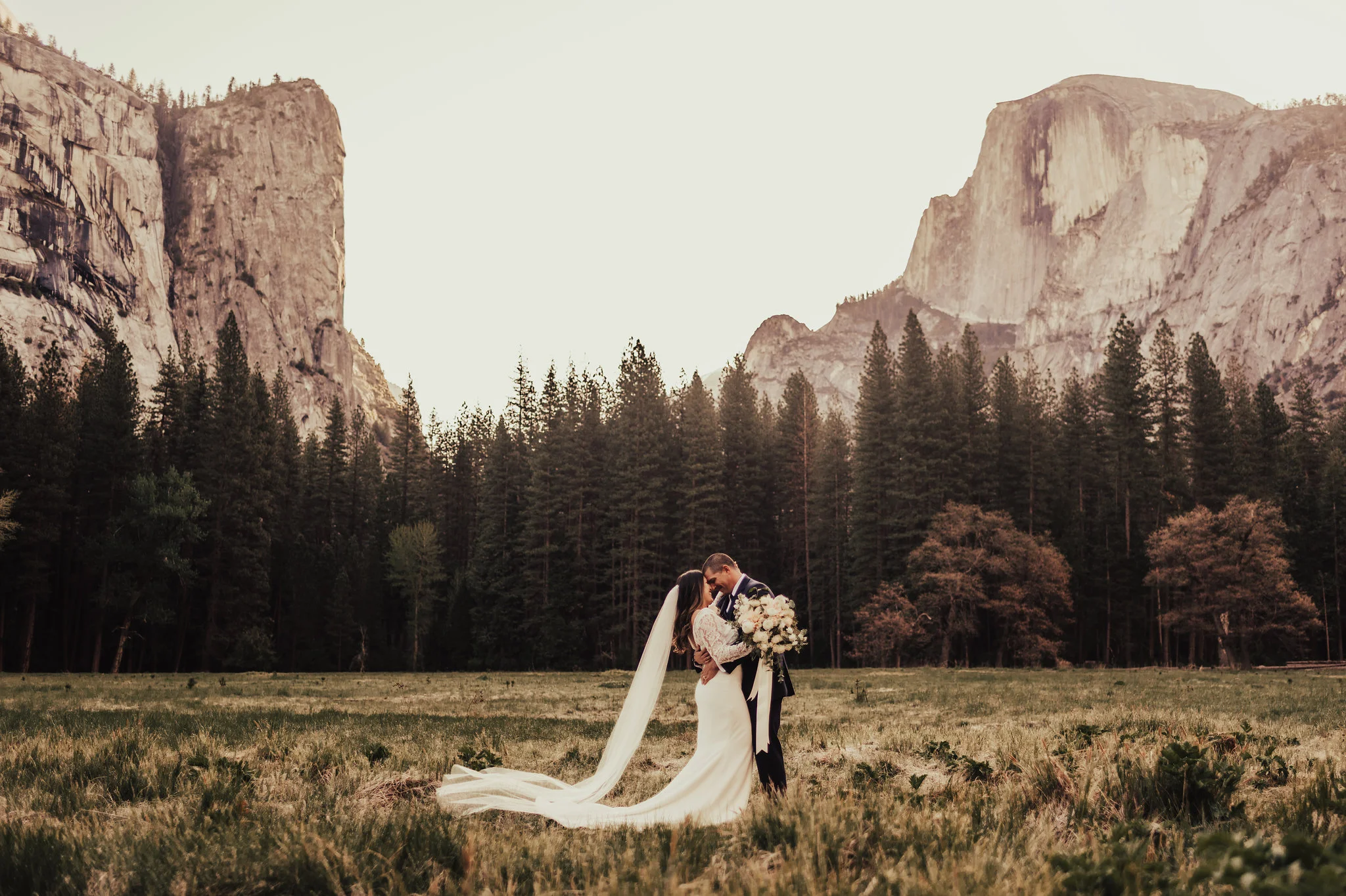 Yosemite bride shares sweet kiss with groom in front of Half Dome photographed by Big Sur Wedding Photographers Tessa Tadlock 