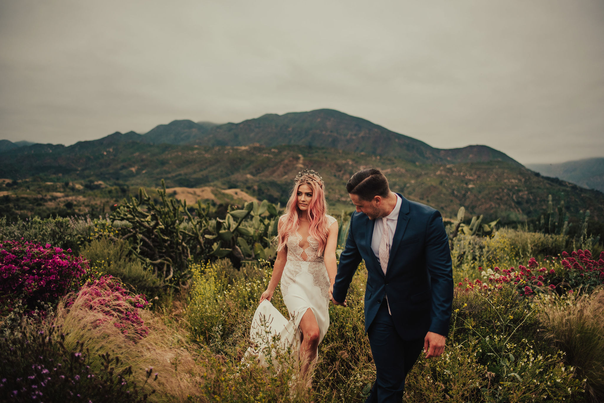 Groom Leads Boho Bride through Field of Wildflowers Photographed by Big Sur Wedding Photographers Tessa Tadlock