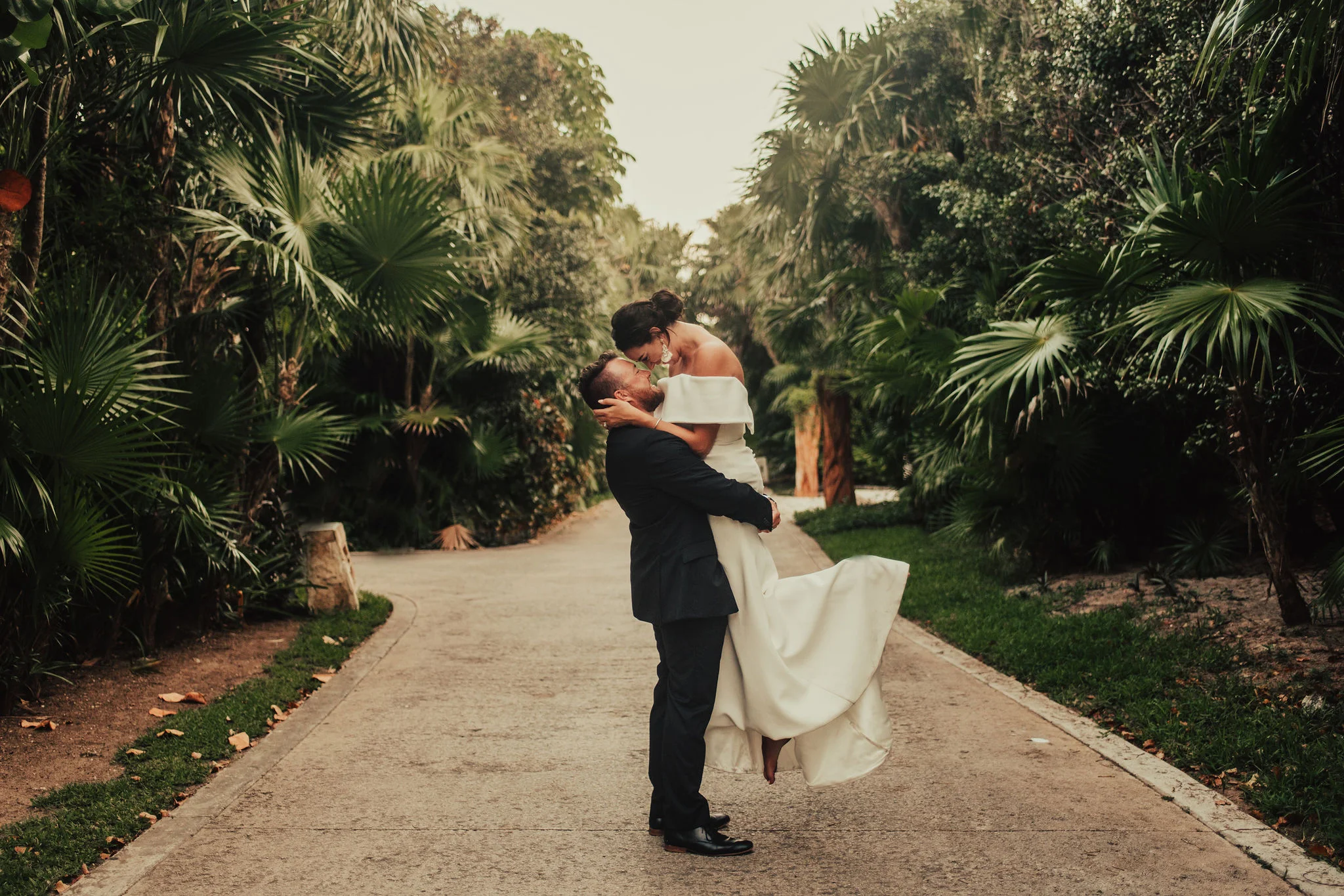 Tropical Wedding with Portrait of Groom Lifting Bride Photographed by Big Sur Wedding Photographers Tessa Tadlock