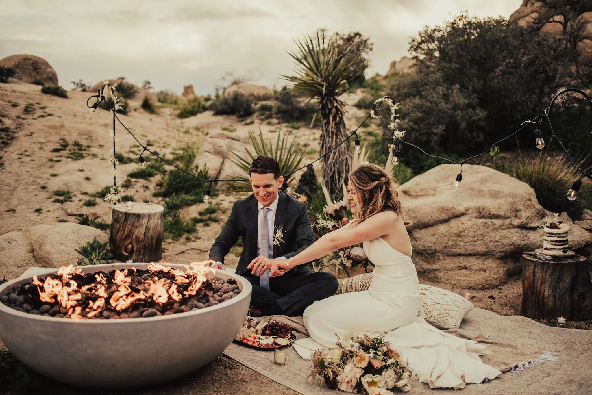 Cute Couple by a Cozy Firepit after Joshua Tree Elopement Photographed by Big Sur Wedding Photographers Tessa Tadlock
