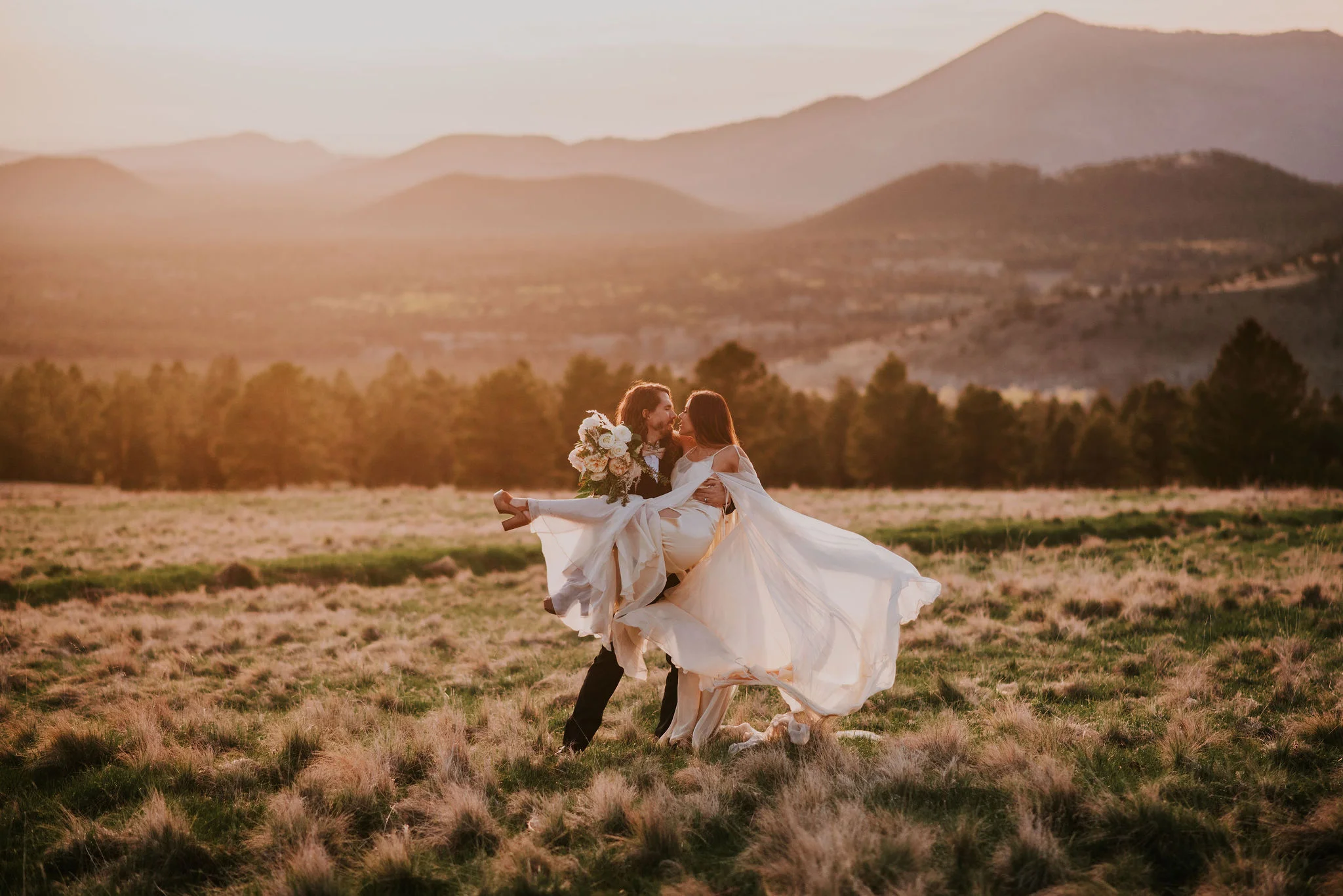 Groom Twirls Bride at Sunset in Gorgeous Field Photographed by Big Sur Wedding Photographers Tessa Tadlock