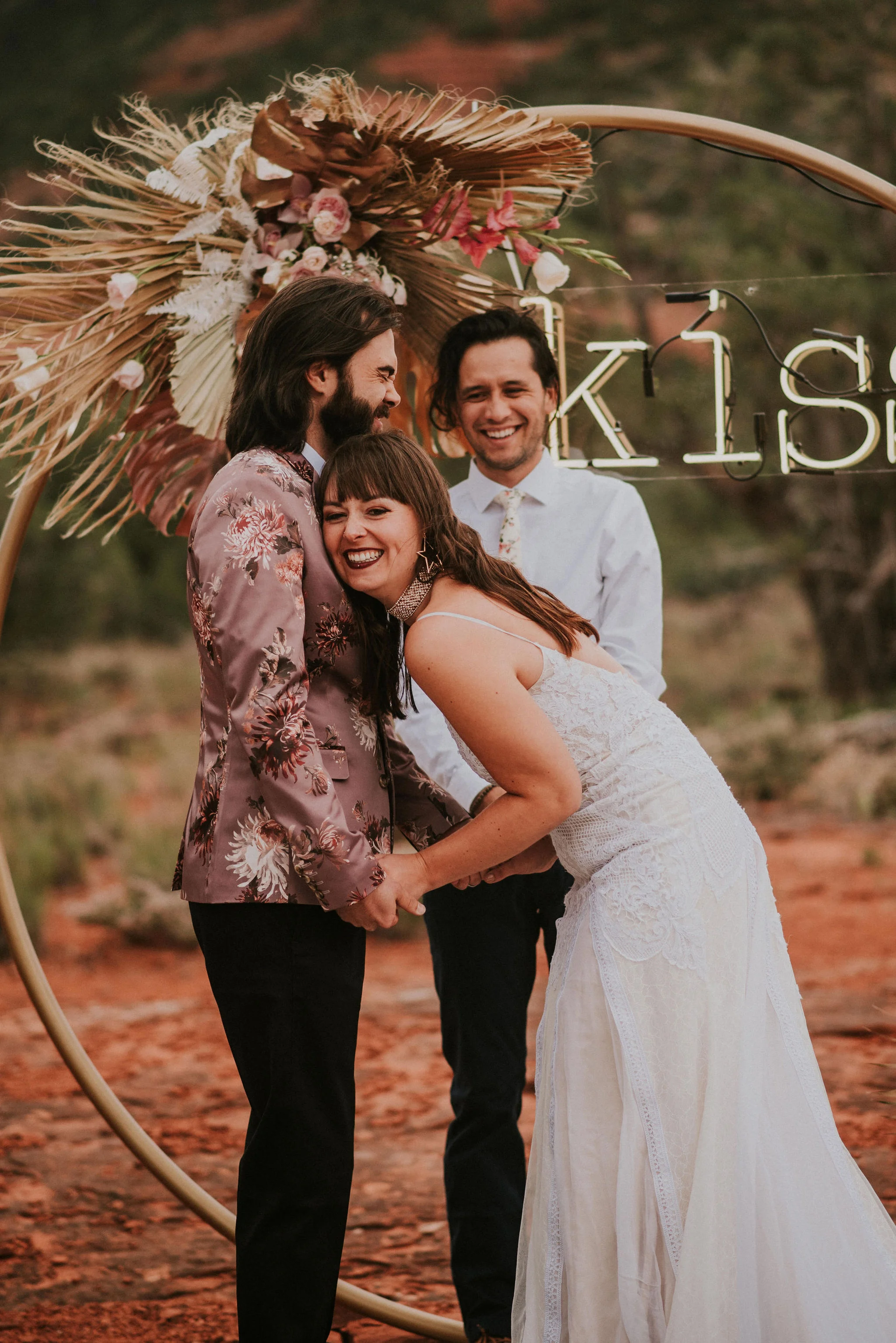 Cutest Ceremony Moment with Happy Bride in front of Neon Kiss Sign Photographed by Big Sur Wedding Photographers Tessa Tadlock