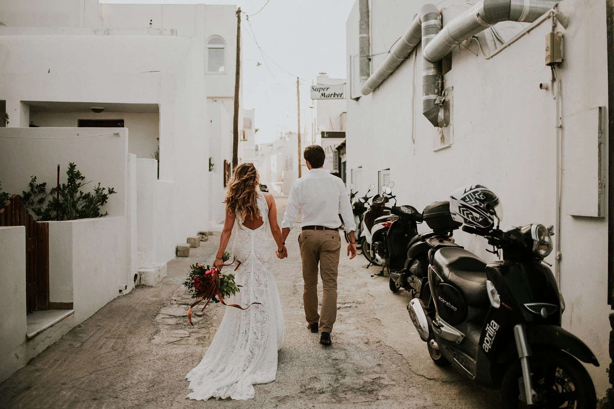 Bride &amp; Groom Walking through Alley in Greece photographed by Big Sur wedding photographers Tessa Tadlock