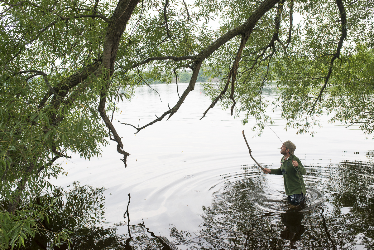 Abdullah walks into the lake to untangle the fishing line. 