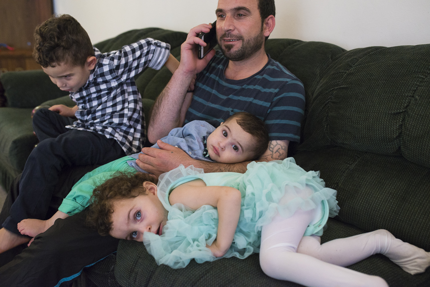  He calls and check with his family who are in Jordan as the children play around him. 