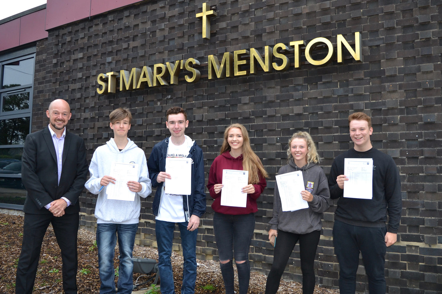 PHOTO: Mr Harvey (Student Progress Leader, Year 11 2015–16 and Year 11 pupils with their results, 25 August 2016