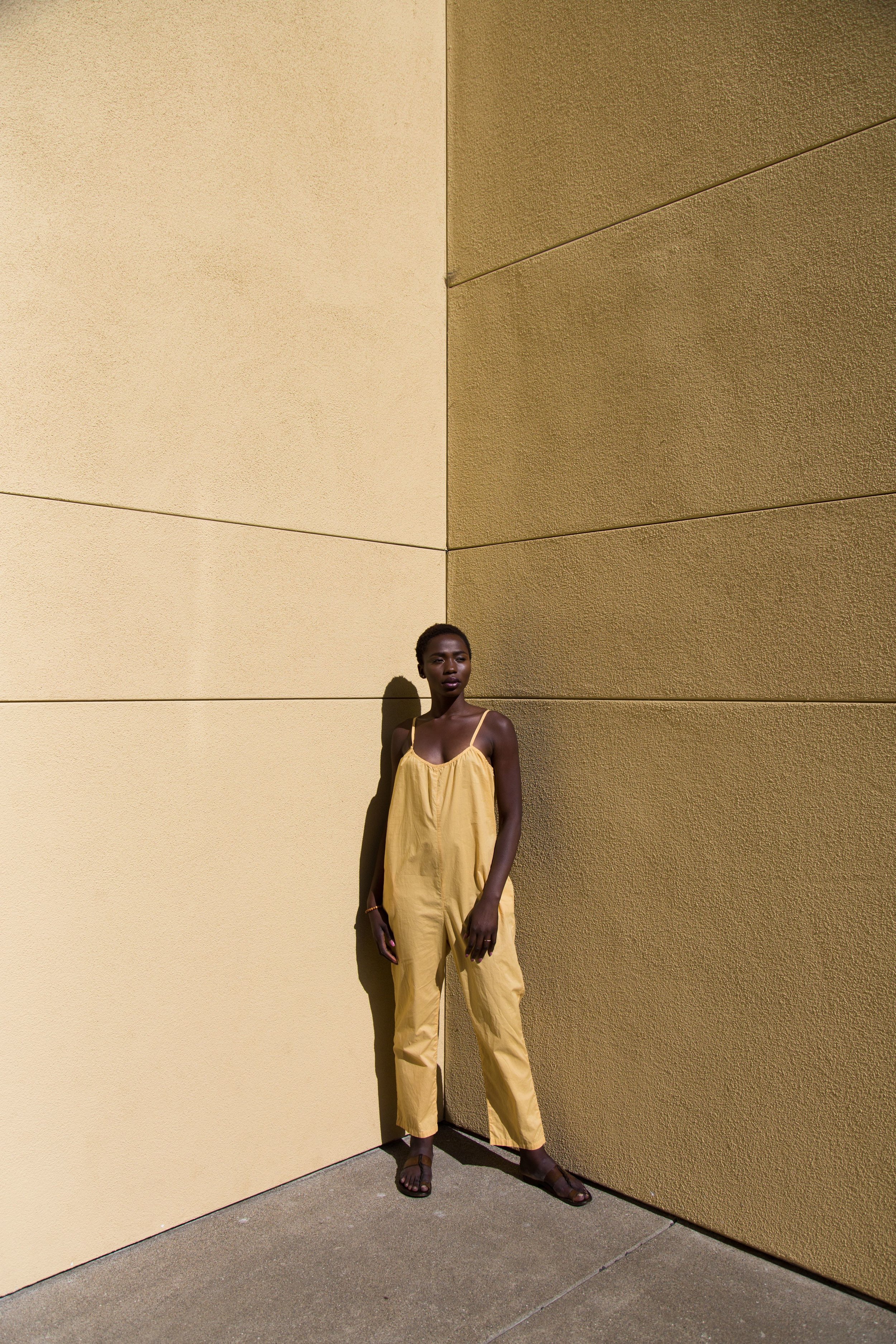 Hawa wears a Sol jumpsuit in gold.