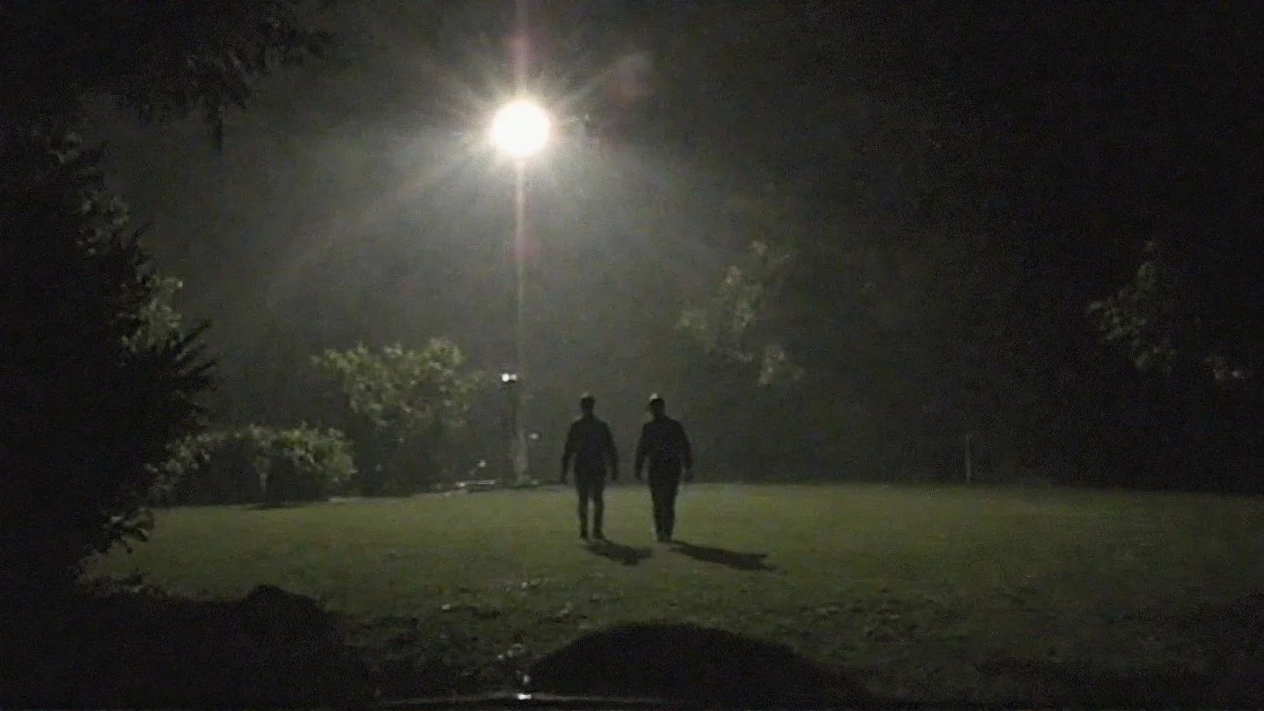 Suspicious men outside on a rainy night