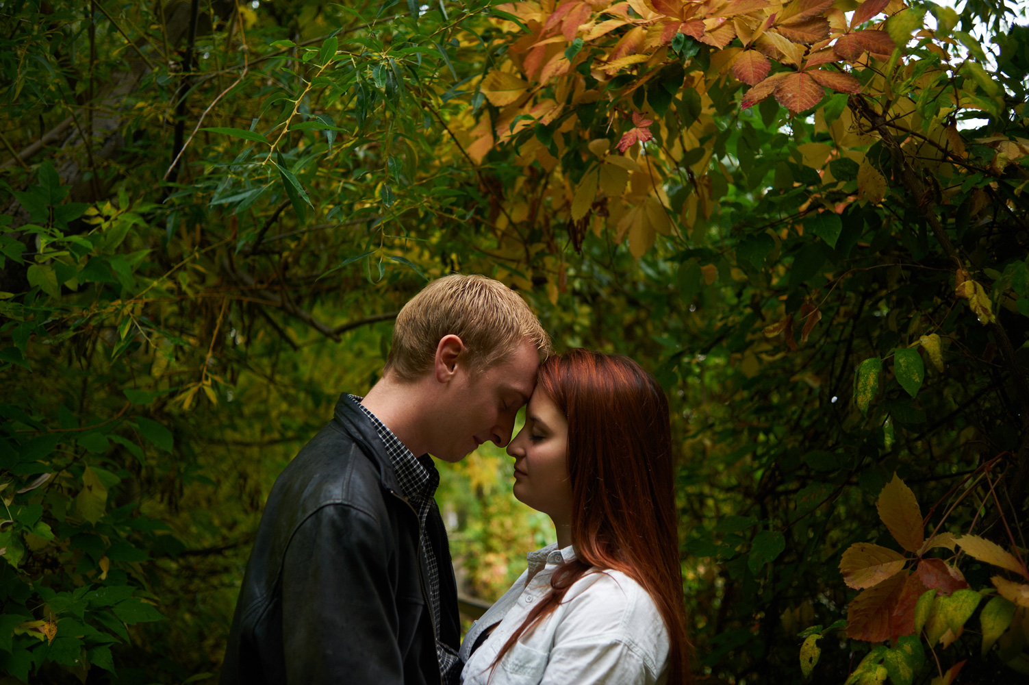 engaged-couple-amongst-colored-leaves-in-fall.jpg