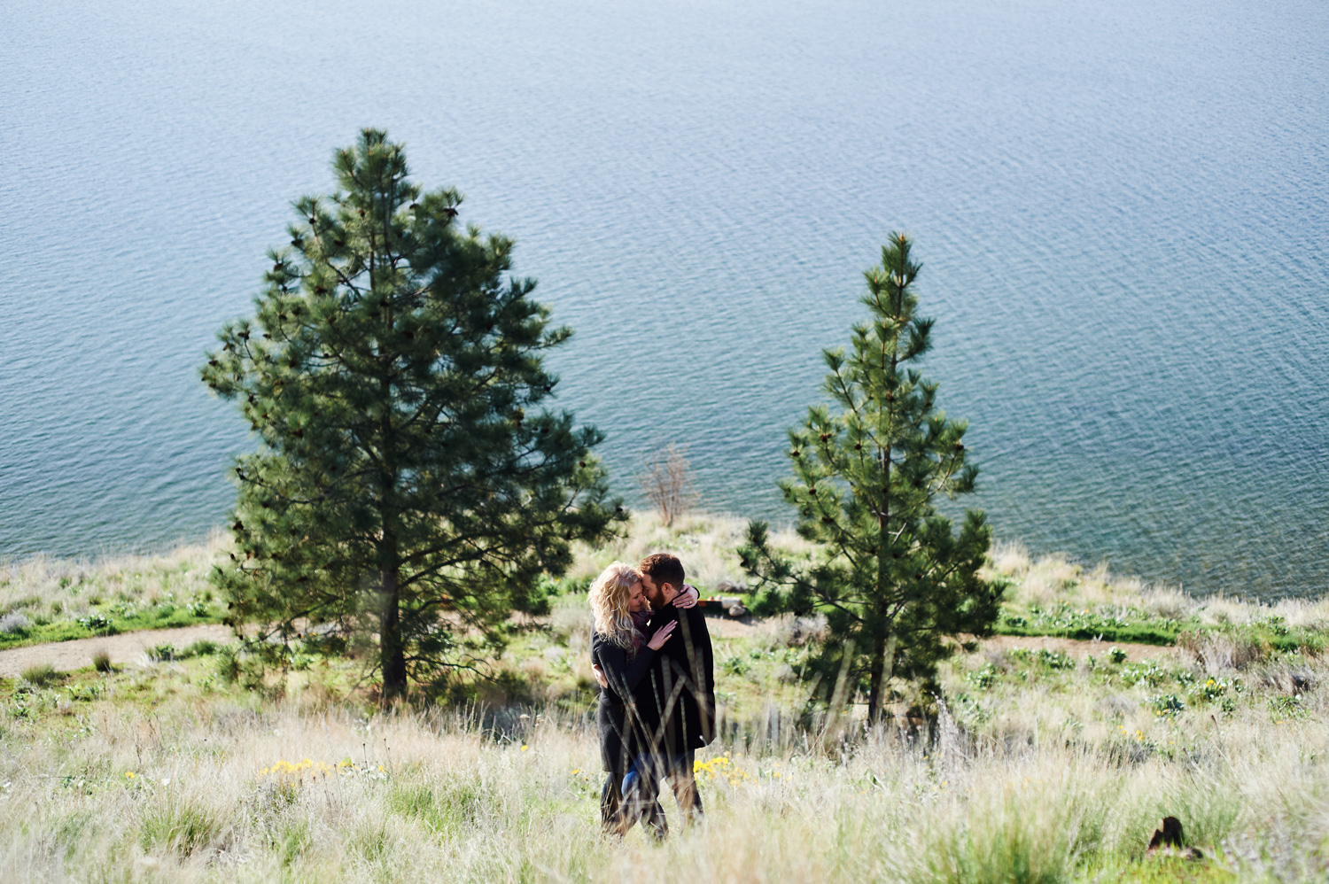 engaged-couple-by-okanagan-lake-by-kelowna-wedding-photographer.jpg