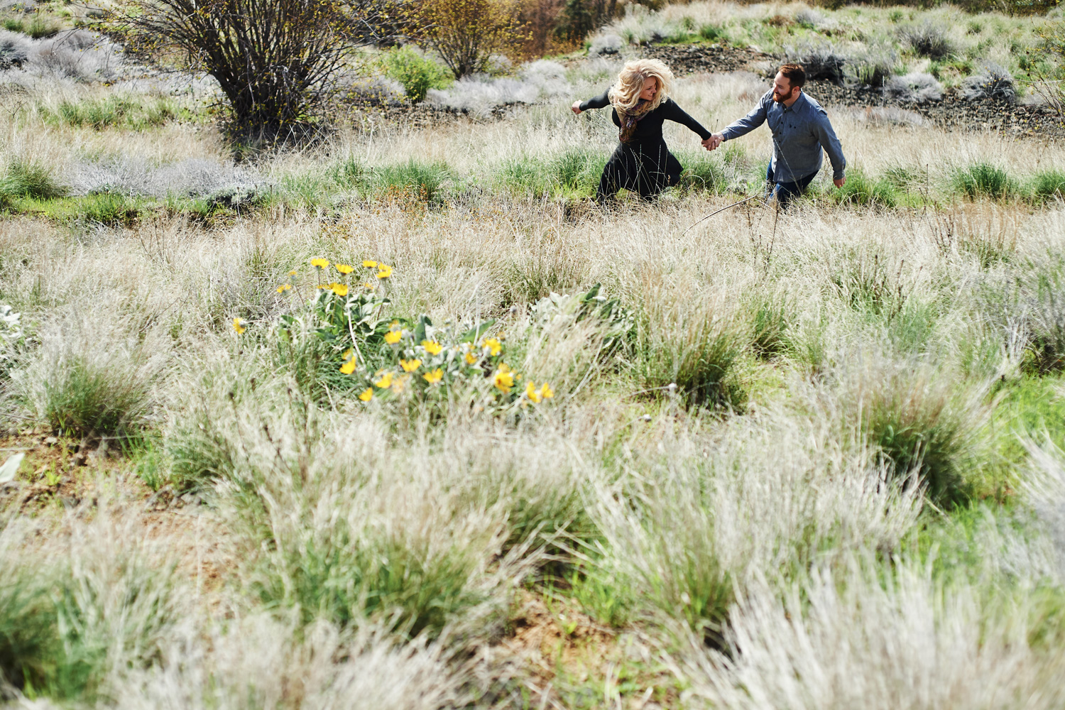 engaged-couple-running-through-a-flower-meadow.jpg