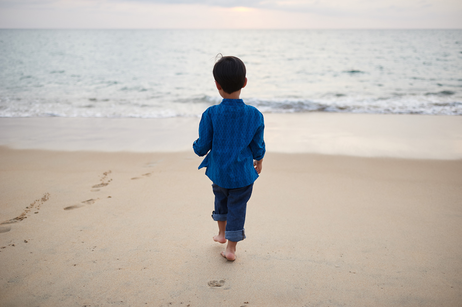 boy-walking-on-sandy-beach-in-thailand-family-session.jpg