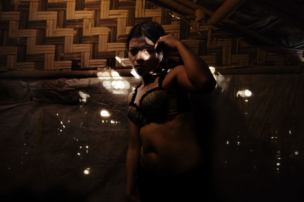 Prostitute posing for a portrait in her room.