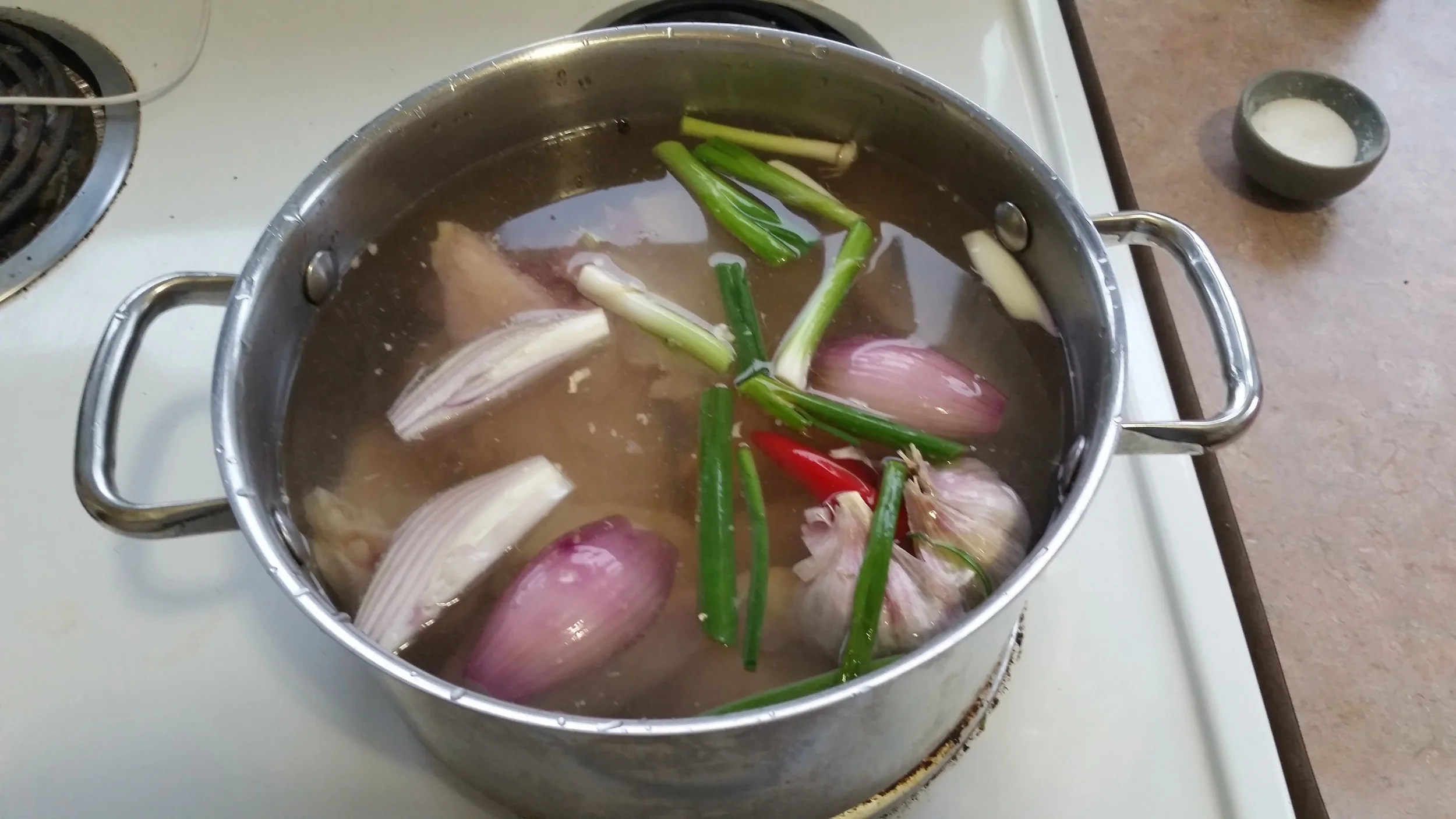 Put the chicken pieces and everything else in a pot, cover with water. Turn up the heat to medium high and bring to a boil.