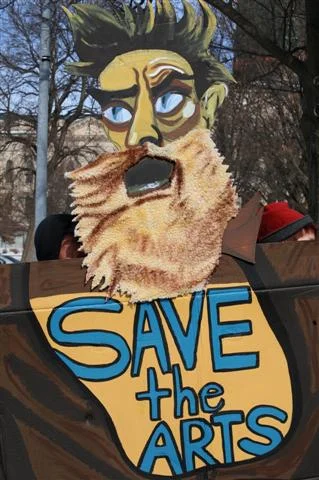 Photo by Ann Dean. For those of you not in Kansas, this cardboard cutout is a take on the mural of John Brown in the Kansas Capitol painted by John Steuart Curry. It was seen at a demonstration for arts funding in 2011, when our governor defunded the Kansas Arts Commission.
