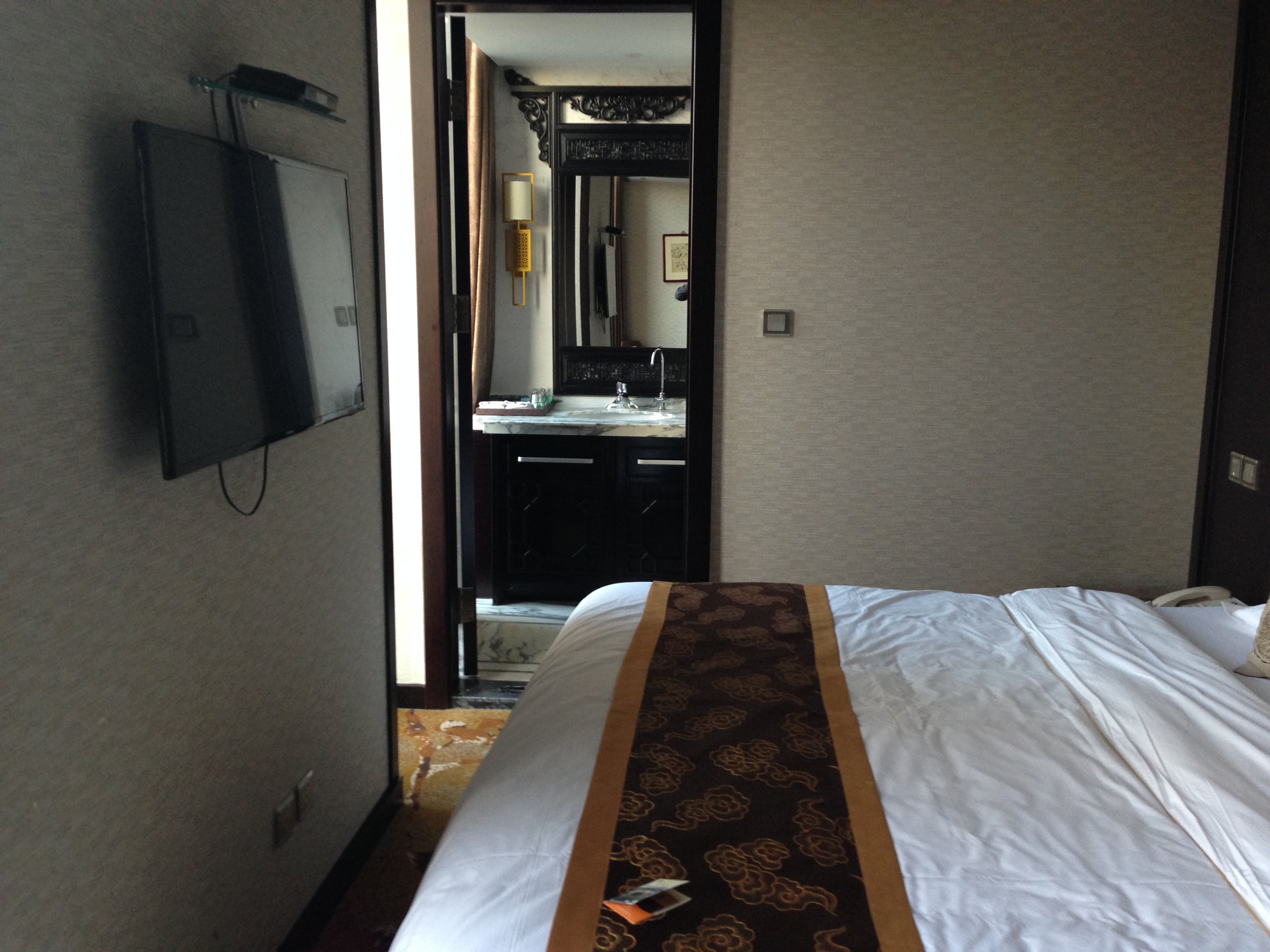 The bed is large, with just enough room to walk by it to the bathroom.