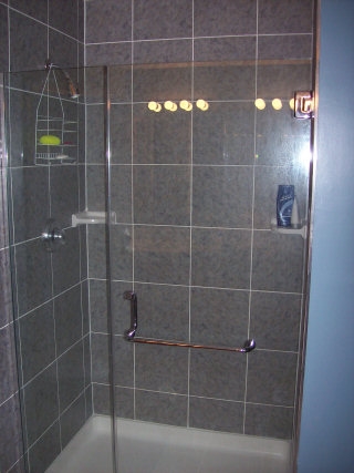   Fiberglass shower stall was removed and a shower pan was added with 12x12 wall tile over Durock. This was finished off with a seamless shower door.  