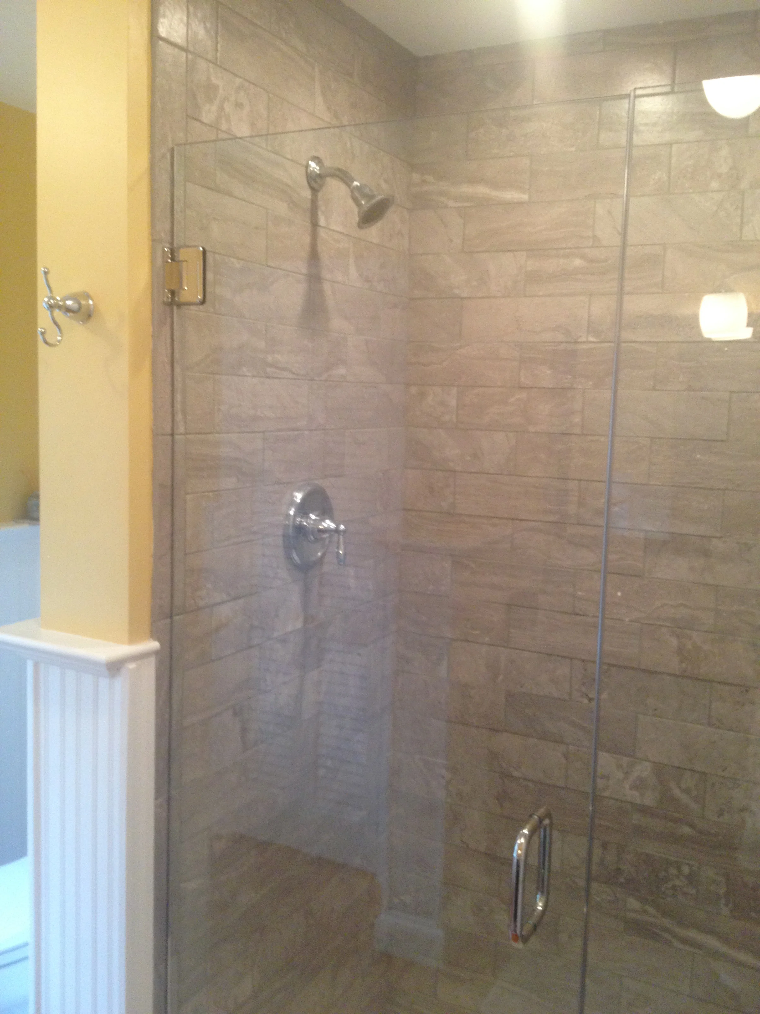 A new tiled shower with a frameless glass enclosure.