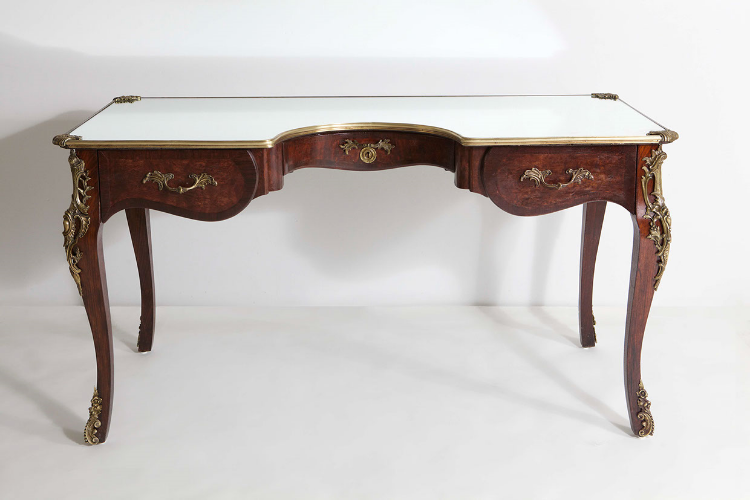 2013 Found antique desk of mahogany, walnut and bronze in form with mirroed glass top 32 3/4 x 59 x 26 3/4 in (83,2 x 149,8 x 67,9 cm) The Narcissus Desk is a new piece by the New York based artist and designer Sebastian ErraZuriz. The desk is a continuation of his functional sculptures, which invite the viewer to look again at everyday objects, spaces and situations. The Narcissus desk was originally inspired by Caravaggio's painting of Narcissus that Sebastian remembers seeing as a child with his father, an art teacher, while on a trip to Italy. The artist explains: “I was struck by the idea that someone could see their reflection and yet not be aware they were looking at themselves. I believe today we are becoming like Narcissus; so obsessed with our own perfectly edited online self that we forget to be aware of the real "me" outside the screen.” The desk wishes to offer the user a moment of reflection, a moment of thought at the one space where we make most of our important decisions in life. In order to fabricate the desk, Sebastian found a broken down French Desk from circa 1880, which he then completely restored. He cut into the original desk with a semi circumference to allow the user to now fit inside the desk. The original top was replaced with a mirror.