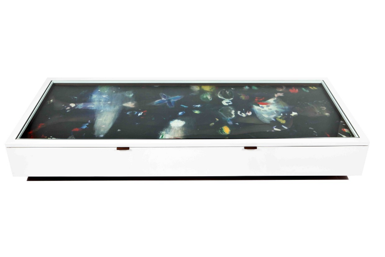 2011 Collaboration with Ross Bleckner Oil on photographic paper, aluminiun, glass, acrylic, wood an steel 34 x 80 x 16 in (86,4 x 203,2 x 40,6cm) Celebrated New York artist Ross Bleckner was Sebastian Errazuriz’s mentor and teacher at the NYU Masters in Fine Arts program. From the first day of class they intellectually challenged each other and have since remained good friends. Both regularly incorporate the awareness of life and death into their work ; Ross Bleckner’s paintings have a tradition of depicting fallen angels, dimming lights, clocks, and funeral flowers dedicated to many of his friends who died of AIDS during the ‘80s. For BODY OF WORK, Errazuriz challenged Bleckner to « stop hiding behind pictorial symbolisms » and address his own mortality. Bleckner accepted the challenge as long as the project was a collaboration. Errazuriz designed two identical coffee tables to resemble coffins in which life-sized photographs of each artist naked placed, as if the artist had passed away, buried underneath their body of work. Bleckner added beautiful layers of paint onto each photograph, and the user was able to remove the paintings from the table, choosing which ones to leave on top or which to hang on the wall. 