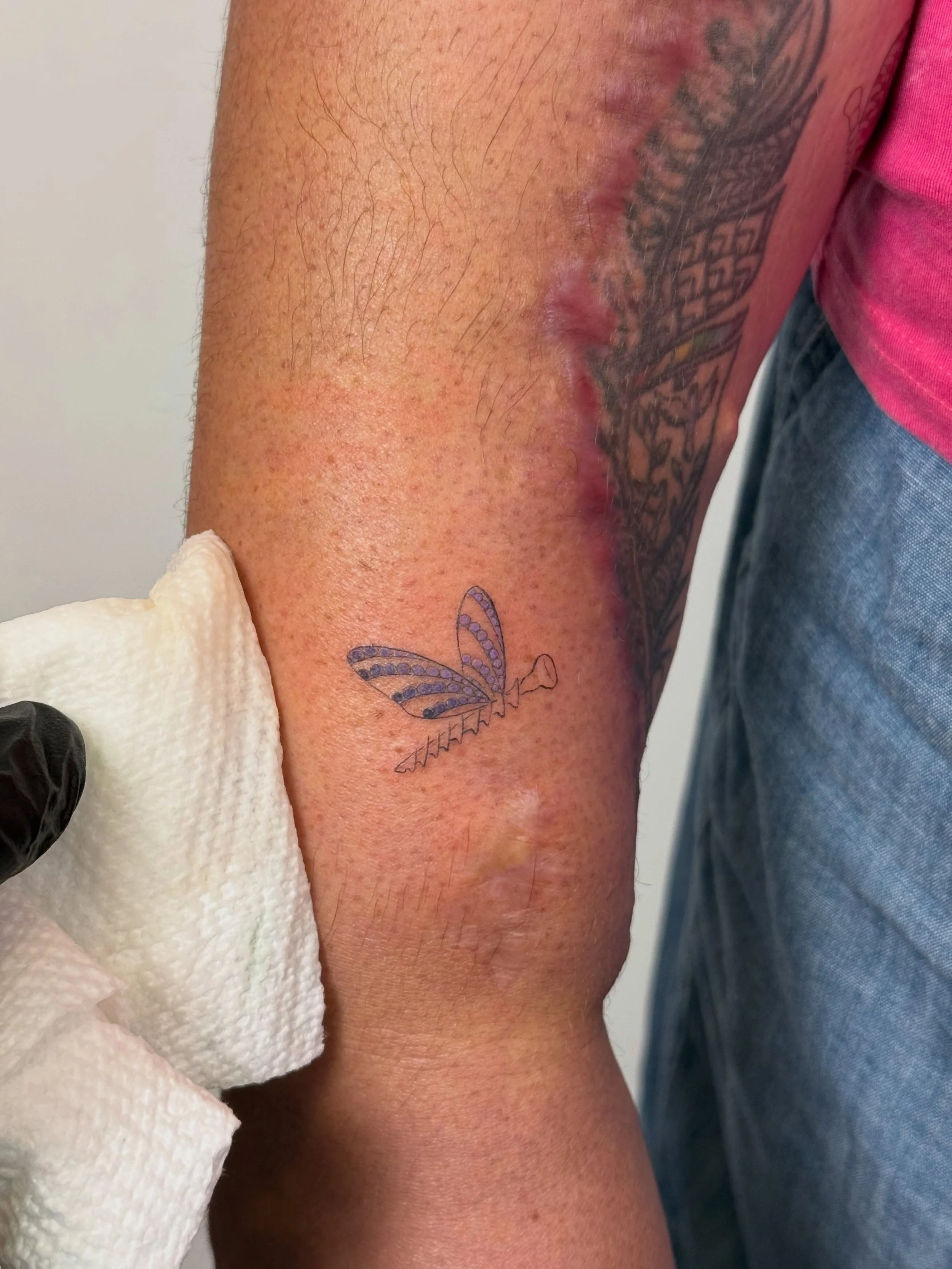 Sara broke her arm in 2021. I had tattooed this quill pen in 2018. After eight surgeries, a good part of her quill pen tattoo was lost. 

Sara dreamed up this idea of bone screw insects flying out from the feather. The zentangle details from that hal